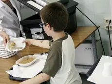 Un bambino alla mensa di una scuola materna