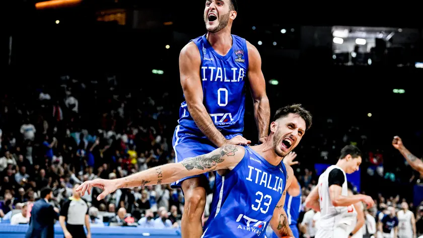 epa10178235 Italian players Marco Spissu (L) and Achille Polonara (R) celebrate after winning in the FIBA EuroBasket 2022 round of 16 match between Serbia and Italy at EuroBasket Arena in Berlin, Germany, 11 September 2022. EPA/FILIP SINGER