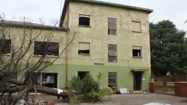 Due immagini dello stabile in via Fratelli Bandiera, rifugio di sbandati e senzatetto. A destra un interno dove si accampano tra i rifiuti alcuni disperati