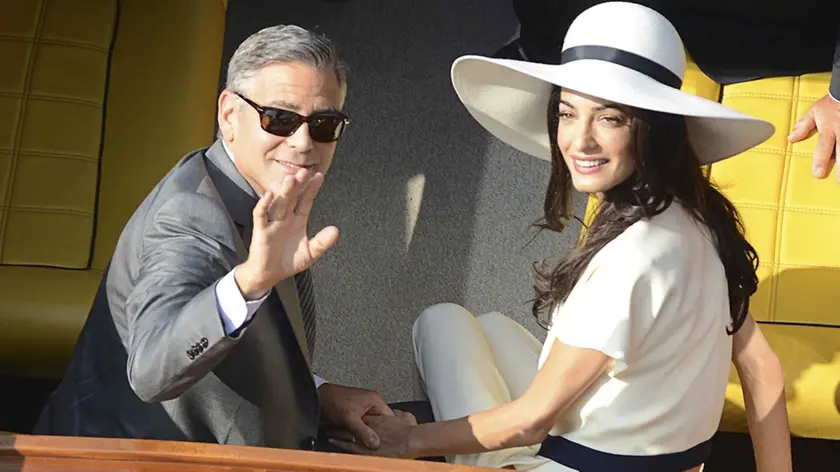 George Clooney and his wife Amal Alamuddin leave the city hall after their civil marriage ceremony in Venice, Italy, Monday, Sept. 29, 2014. George Clooney married human rights lawyer Amal Alamuddin Saturday, the actor's representative said, out of sight of pursuing paparazzi and adoring crowds. (AP Photo/Luigi Costantini)