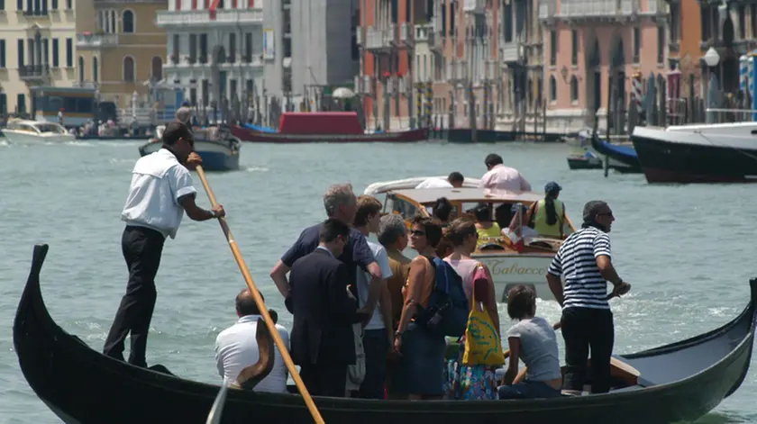 Gondolieri traghettano residenti e turisti dallo stazio di Santa Sofia a Rialto, in un'immagine di repertorio. Servizio pubblico dimezzato al Traghetto di Santa Sofia, punto di imbarco sul Canal Grande, perche' ad una gondola mancano due remi: a causa dei mancati finanziamenti, infatti, il Comune di Venezia per due anni non ha potuto erogare sufficienti risorse all'Ente Gondola, la societa' che gestisce il traghettamento (o 'parada') su gondola da riva a riva del 'Canalazzo' e la manutenzione delle relative strutture. Pertanto, per una decina di giorni, funzionera' una sola gondola delle due che normalmente da Santa Sofia fanno la spola tra il Sestiere di Cannaregio e il Mercato di Rialto: la seconda e' rimasta senza remi. ANSA/ANDREA MEROLA