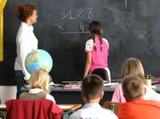 intÃ©rieur salle de classe, institutrice regardant fillette de dos au tableau, faisant multiplication, garÃ§ons et fillettes assis au 1er plan