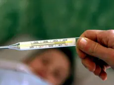 Un termometro per misurare la febbre ad un bambino a letto con l'influenza, in un'immagine d'archivio. Dall' 8 al 14 gennaio 2018 il numero degli italiani colpiti dall'influenza è stato pari a circa 832.000 e gli italiani messi a letto dal virus sono quasi 4 milioni, piu' precisamente 3.883 mila. E' quanto emerge dal nuovo rapporto epidemiologico Influnet a cura dell'Istituto superiore di sanità e relativo alla seconda settimana del 2018. Piu' colpiti i bambini. FRANCO SILVI /ANSA