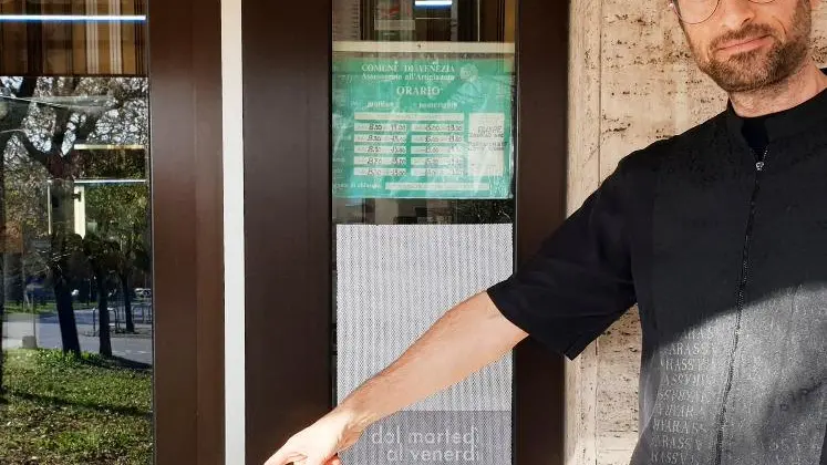 Il titolare di Equipe Zagallo mostra la vetrata del negozio