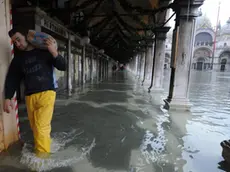 20081212 - VENEZIA - WEA - MALTEMPO: VENEZIA; ACQUA ALTA, MASSIMA MAREA A 110 CM - Un lavoratore passa sotto il porticato di piazza San Marco, stamattina 12 dicembre 2008 a Venezia. L'acqua alta ha raggiunto alle 9.45 di oggi a Venezia una massima di marea di +110 centimetri, corrispondente ad un allagamento del 23% del centro storico, rispettando le previsioni della vigilia. Per questa sera il Centro maree del Comune ha ipotizzato alle 23:25 un nuovo 'picco' di +105 centimetri. Andrea Merola/ANSA /KLD