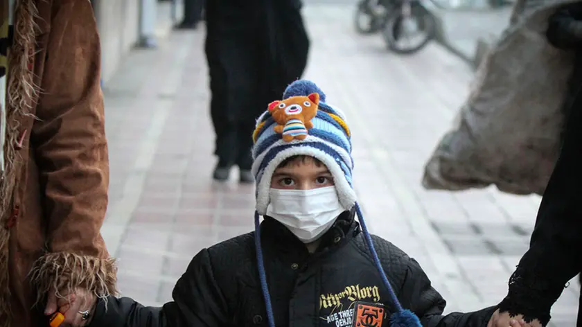 (151221) -- TEHRAN, Dec. 21, 2015 (Xinhua) -- An Iranian boy wearing a protective mask walks on a street in downtown Tehran, Iran, on Dec. 20, 2015. Iran's government announced that all schools and kindergartens of Tehran close on Dec. 20 and 21, due to the alarming high air pollution in the city. (Xinhua/Ahmad Halabisaz)..