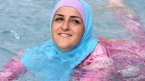 A young Turkish woman cools off while wearing a burkini at an open-air bath in Berlin, Germany, 20 August 2012. ANSA/STEPHANIE PILICK