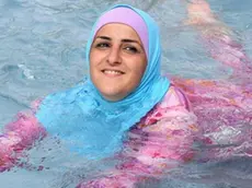 A young Turkish woman cools off while wearing a burkini at an open-air bath in Berlin, Germany, 20 August 2012. ANSA/STEPHANIE PILICK