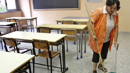 Una bidella pulisce un'aula il primo giorno di scuola al liceo Newton di Roma, oggi 12 settbre 2011 a Roma. ANSA/ALESSANDRO DI MEO