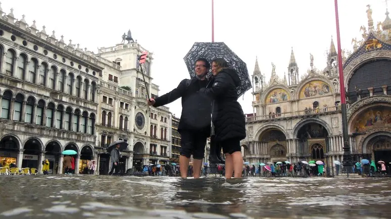 Turisti in Piazza San Marco con l'acqua alta