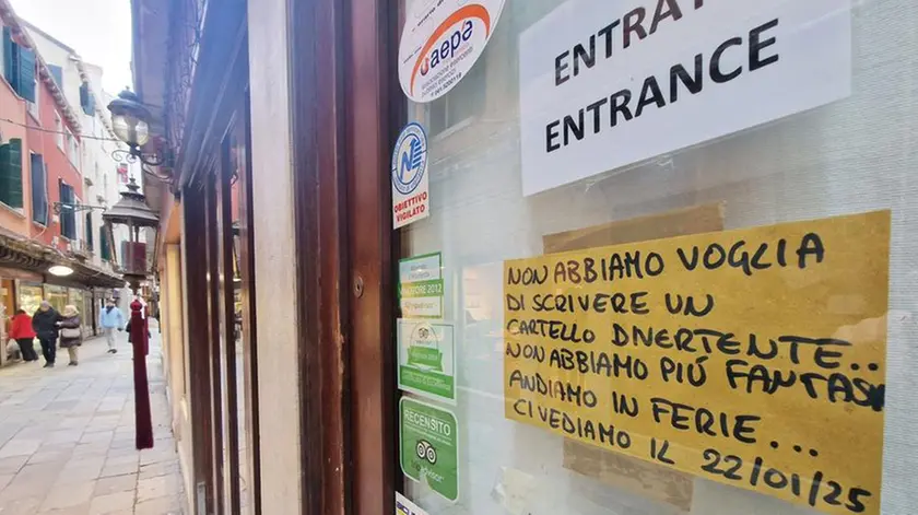 Un cartello affisso a un locale in centro storico