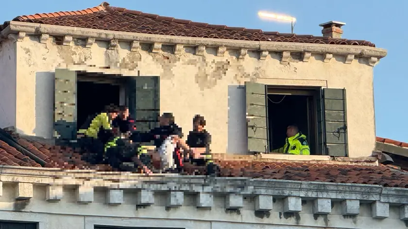 I soccorritori sul tetto dell'edificio che si affaccia sul Canal Grande