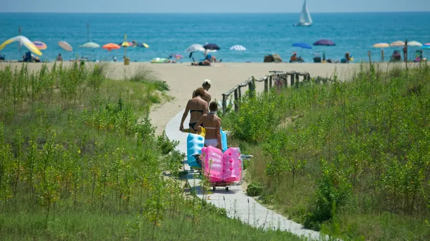 Turisti mentre si dirigono in spiaggia a Cavallino