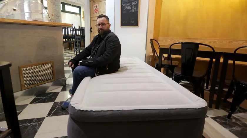 Fabio Bobbo, titolare della birreria Tarvisium, con il letto di fortuna allestito nel locale