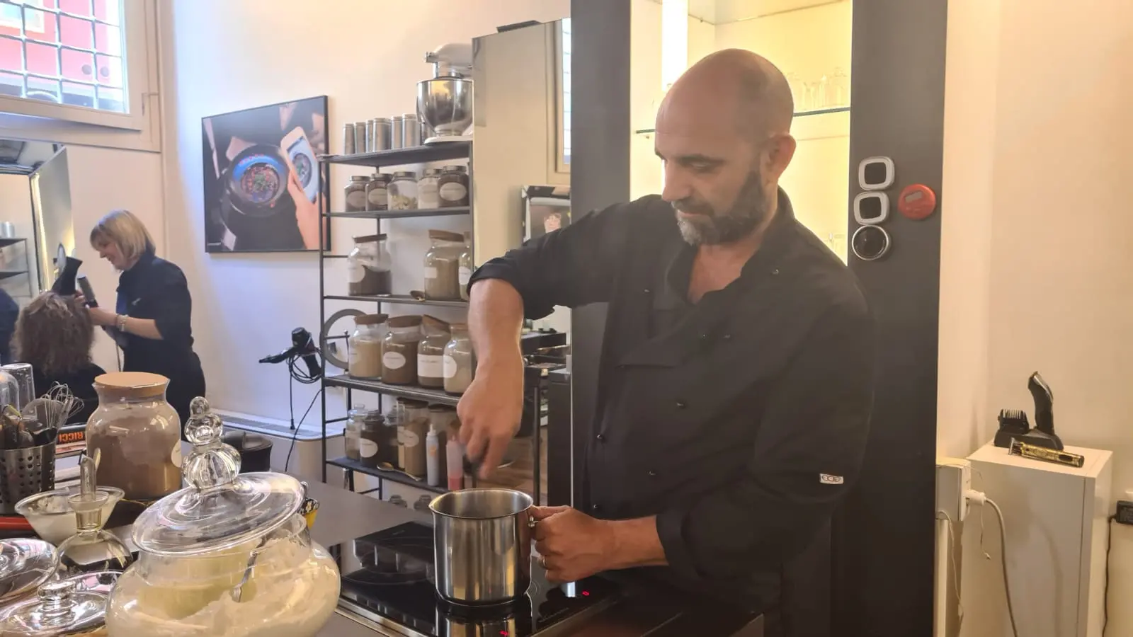 Fabio Cavalletto mentre cucina nel suo negozio di parrucchiere