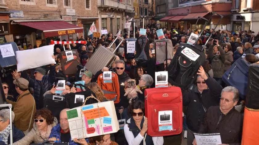 Venexodus: veneziani con i trolley “cacciati” dalla loro città da un turismo imperante. Una manifestazione del 2016