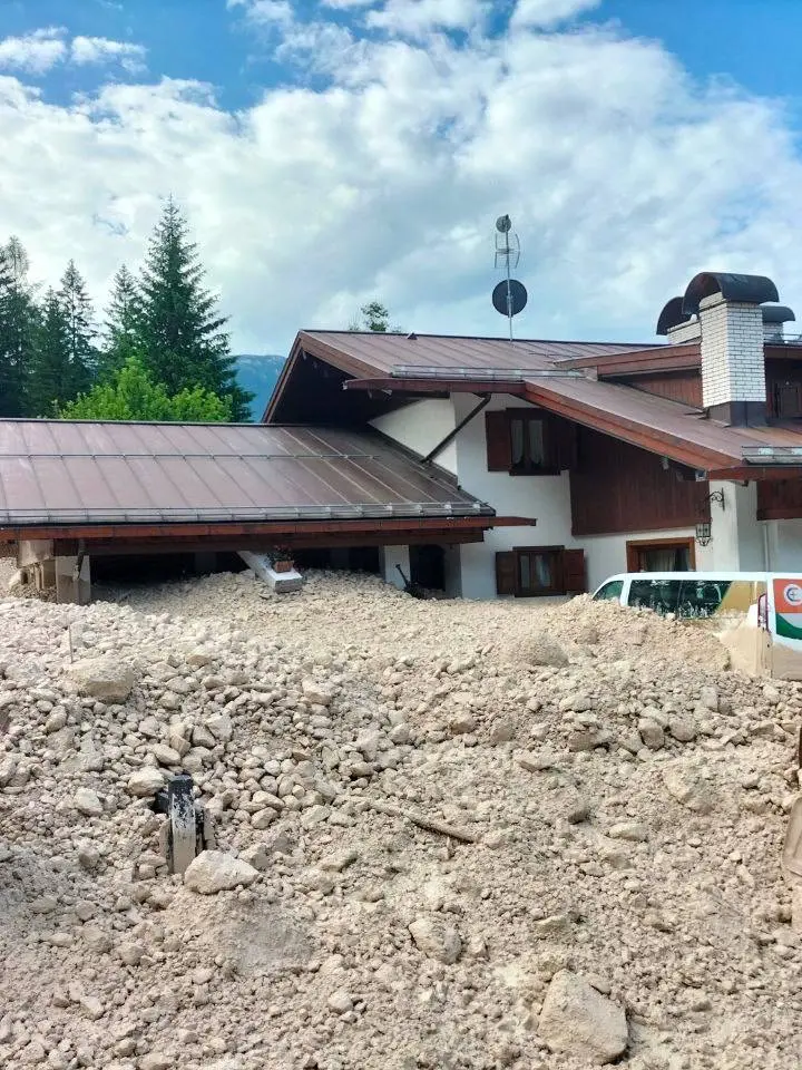 Una casa invasa da sassi e ghiaia della frana a Cancia (foto vigili del fuoco)