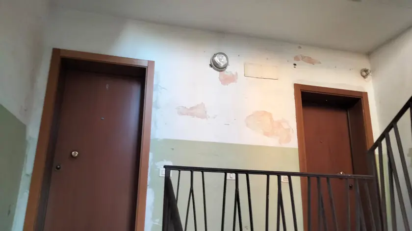 I muri scrostati in un condominio popolare in via della Rinascita
