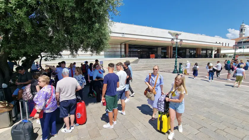 Turisti davanti alla stazione di Venezia dove è guerra tra facchini regolari e abusivi