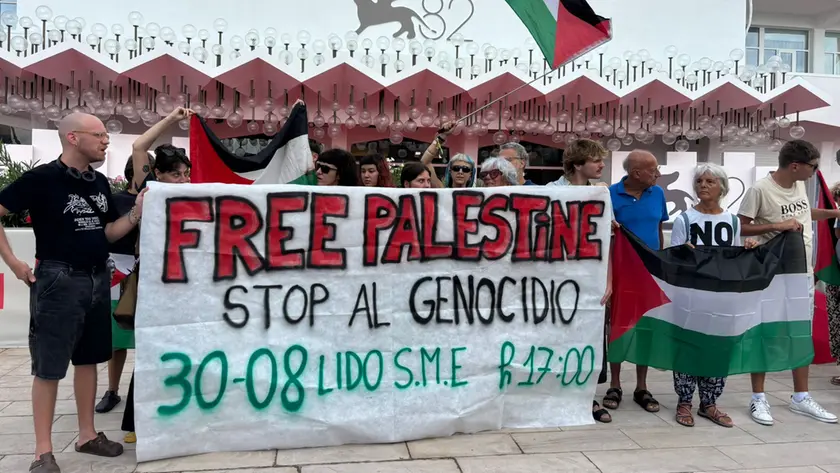 I manifestanti con lo striscione pro Palestina davanti al red carpet