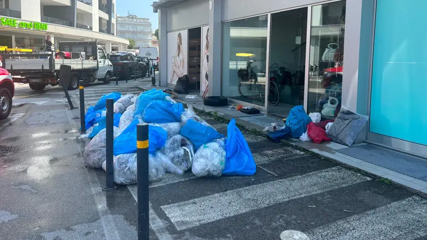 Un mucchio di rifiuti davanti ad un negozio in centro a Bibione