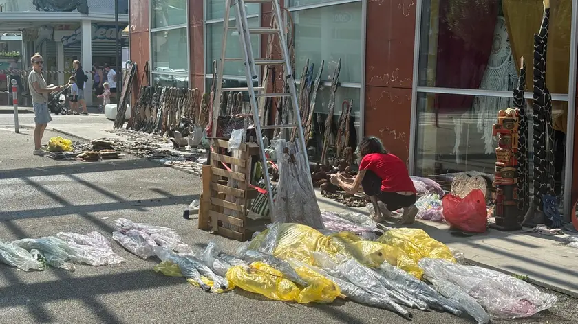 Merce messa ad asciugare e da buttare sui marciapiedi davanti a due negozi in via delle Costellazioni (foto Bortoluzzi)