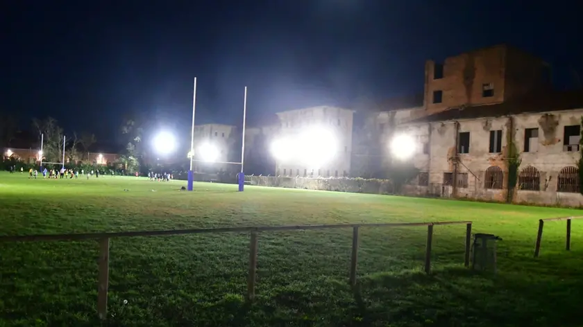 Il campo da rugby e sullo sfondo l'edificio da cui è caduta la ragazza di 17 anni