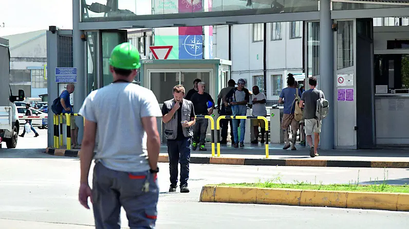 Operai di fronte ai cancelli dello stabilimento Fincantieri di Panzano