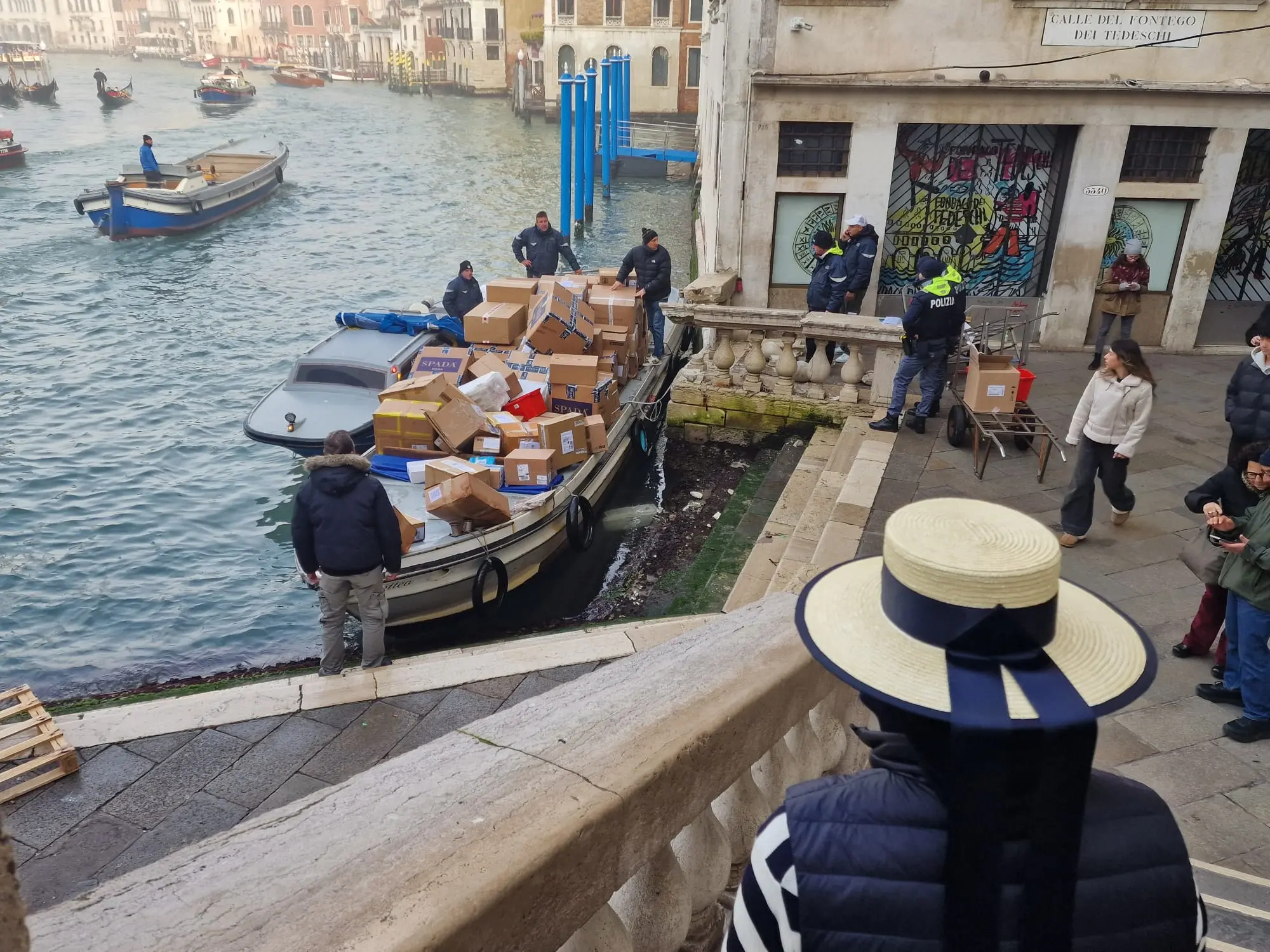 Furto rocambolesco sul Canal Grande: una donna ruba una barca FedEx ormeggiata a Rialto e tenta una breve fuga tra i palazzi storici. Dopo pochi metri di manovre confuse, l’imbarcazione sbatte contro il parapetto vicino al Fondaco dei Tedeschi, mettendo fine all’improvvisata corsa sul canale