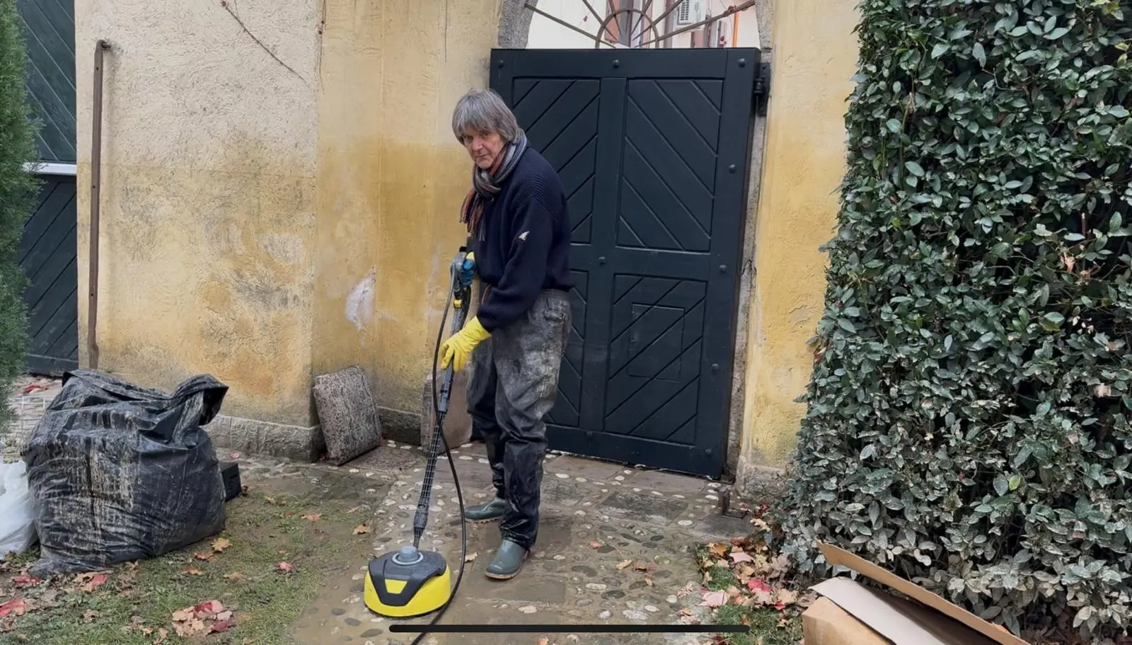 Il pittore e designer Dario Delpin pulisce il suo giardino finito sott'acqua nella sua casa di Versa