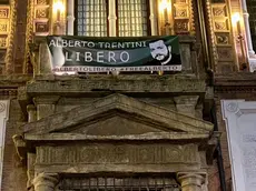 Lo striscione sul municipio di Bologna