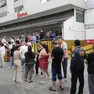 Cittadini in coda davanti a un supermercato a Caracas