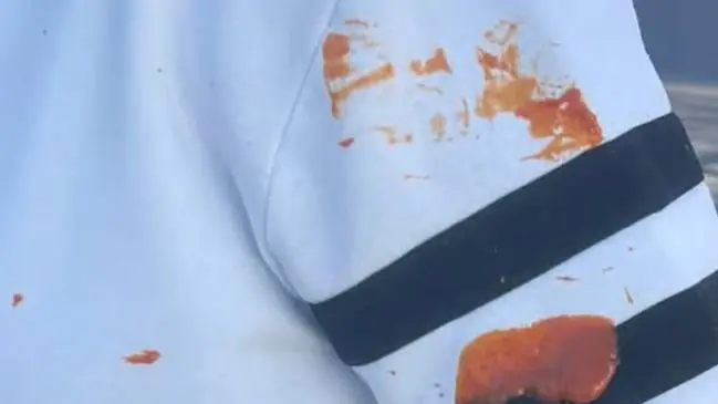 Un passante colpito dalla salsa di pomodoro