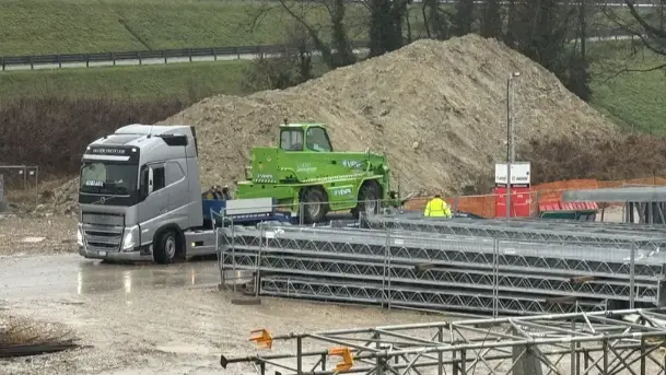 I tir portano via i macchinari dal cantiere della bretella (Foto Porcile)