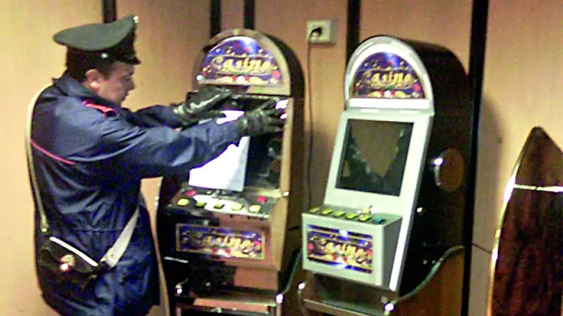 Un carabiniere durante un controllo a una slot machine in un locale pubblico