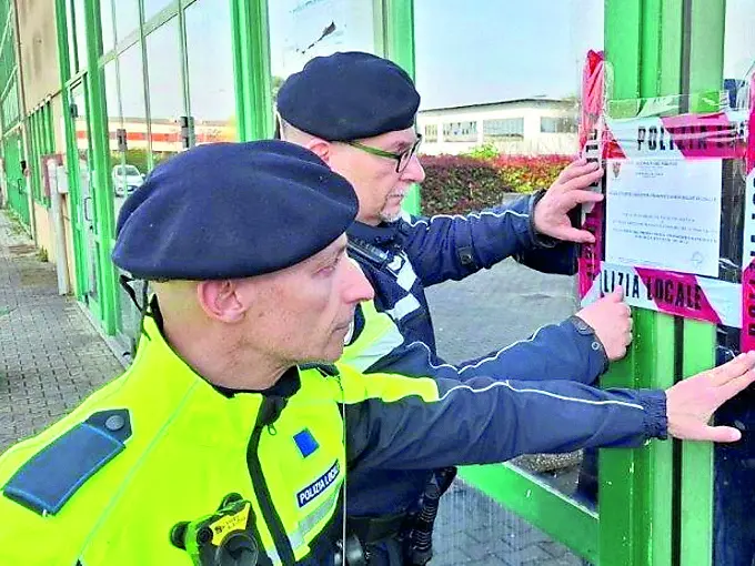 Gli agenti della polizia locale mettono i sigilli al locale