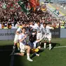 Un gruppo di giocatori festeggia la promozione
