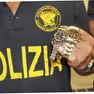 In una foto d'archivio un poliziotto mostra due Rolex recuperati.