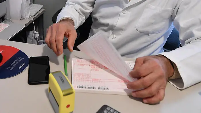 Un medico di base con il ricettario