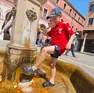 Un bambino trova refrigerio in una fontana