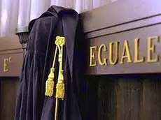 Una toga appesa sulla scritta La legge è uguale per tutti. Immagine simbolo della legge, tribunale.