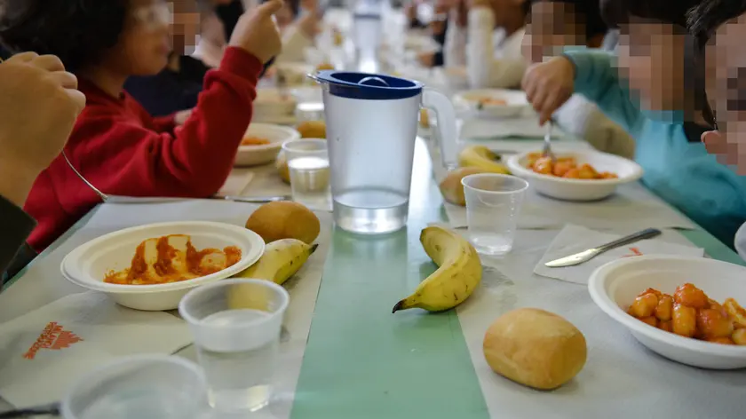 Bambini mentre consumano il pranzo in una mensa scolastica