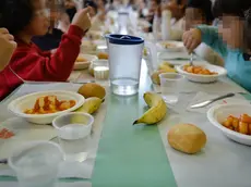 Bambini mentre consumano il pranzo in una mensa scolastica