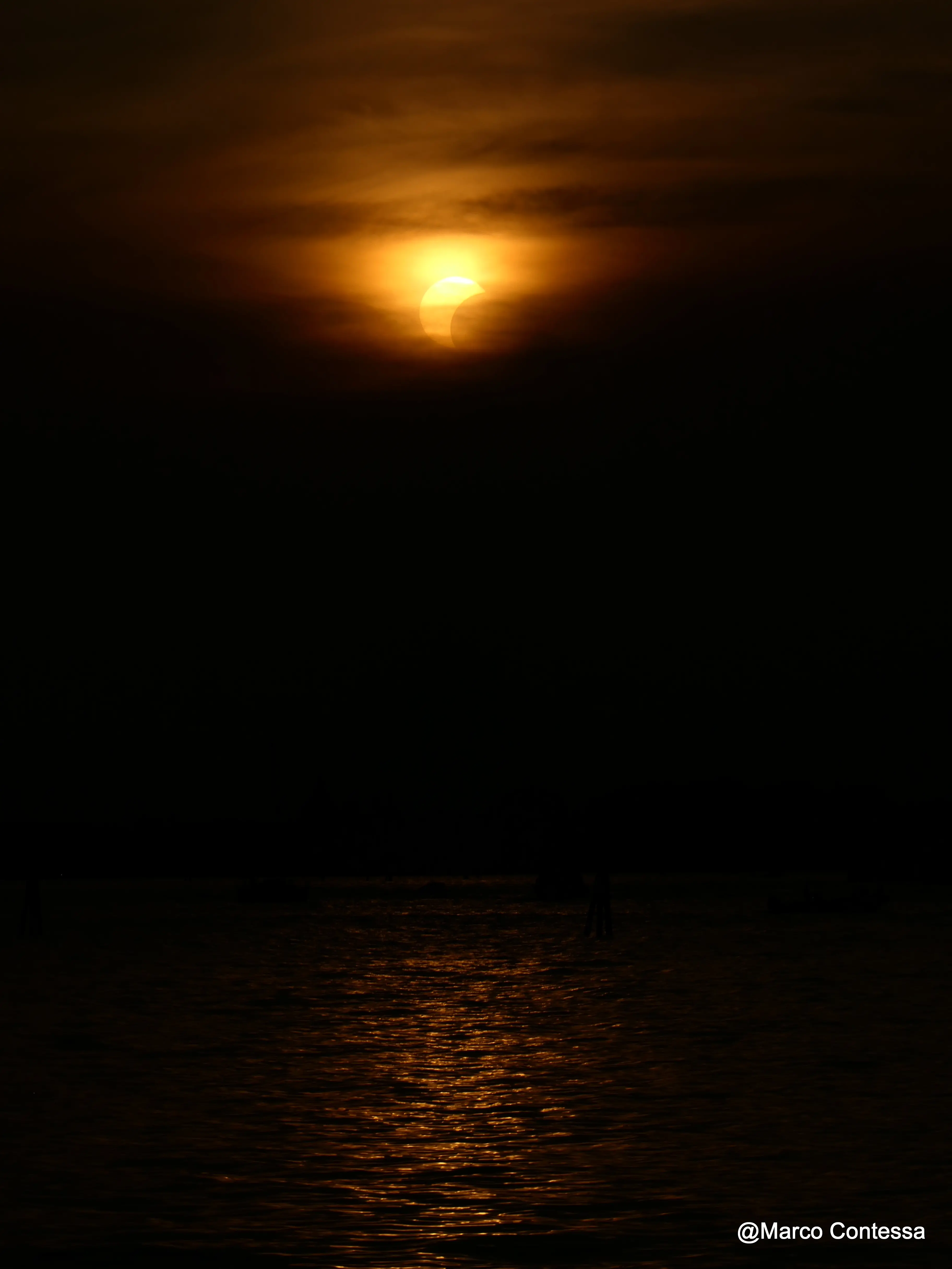La luce che cambia, il Sole che si oscura e Venezia che per qualche minuto assume colori insoliti. Tra mare, profili della laguna e cielo, le immagini dell’eclissi di Sole vista da Venezia raccontano uno spettacolo raro e suggestivo. Le foto sono di Marco Contessa