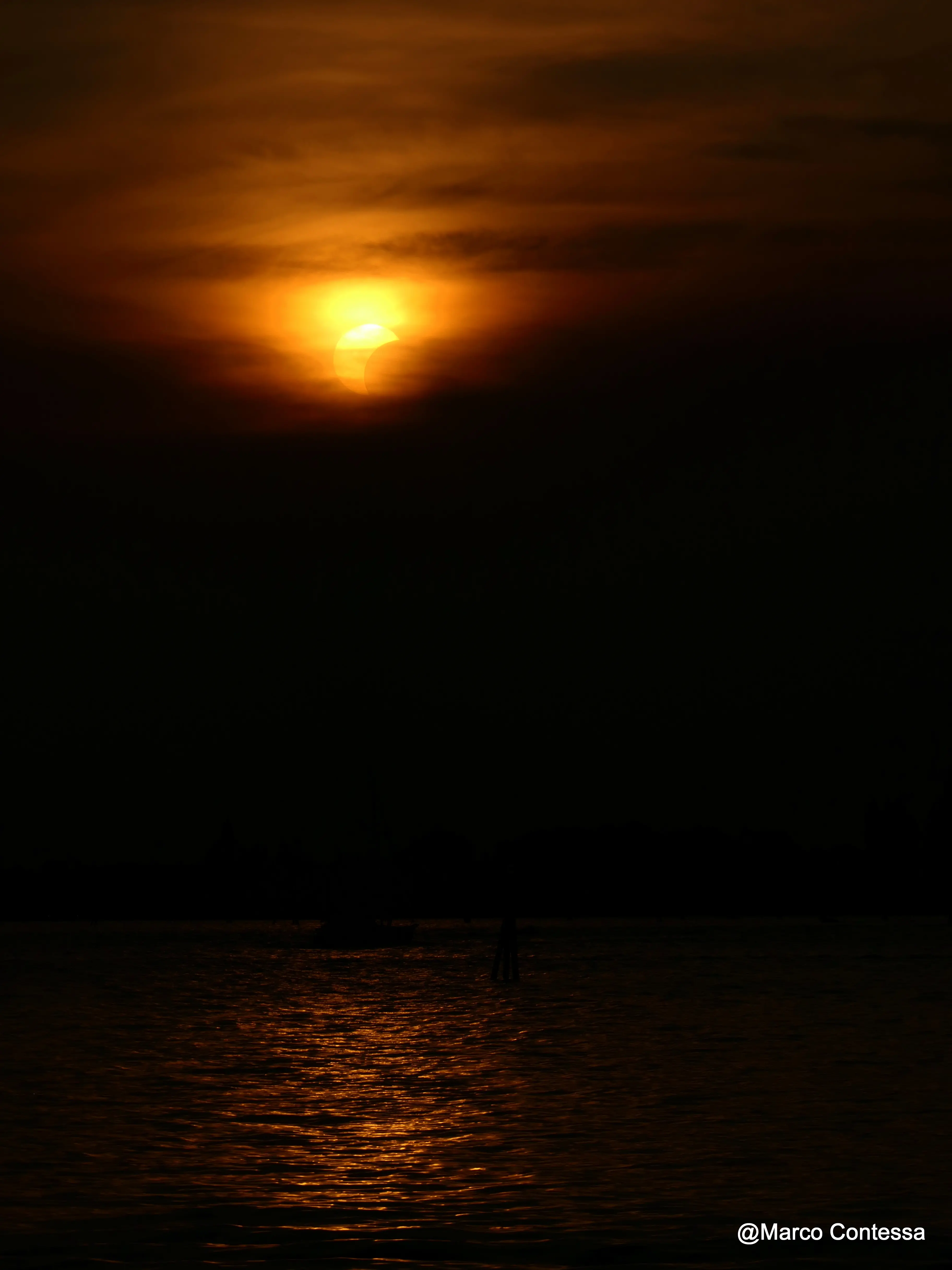 La luce che cambia, il Sole che si oscura e Venezia che per qualche minuto assume colori insoliti. Tra mare, profili della laguna e cielo, le immagini dell’eclissi di Sole vista da Venezia raccontano uno spettacolo raro e suggestivo. Le foto sono di Marco Contessa