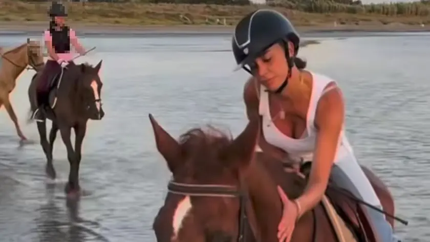 Belen cade da cavallo sulla spiaggia