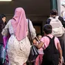 Una mamma con il velo accompagna il figlio a scuola