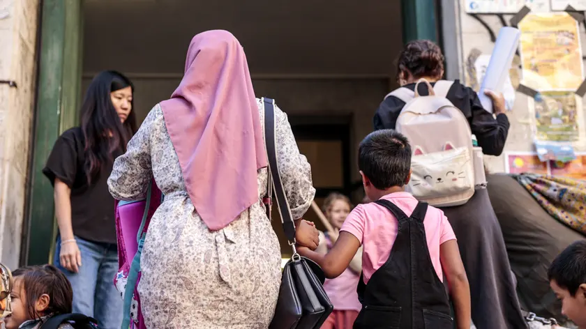 Una mamma con il velo accompagna il figlio a scuola