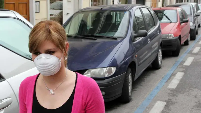 Una ragazza con mascherina anti - smog.