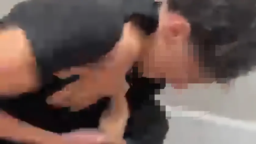 Un momento del pestaggio nel bagno della scuola